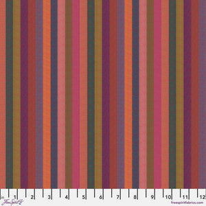 A woven fabric featuring narrow stripes in a range of colors including orange, pink, and sunset hues, with a label indicating the brand Kaffe Fassett and the pattern name WOVEN STRIPES.
