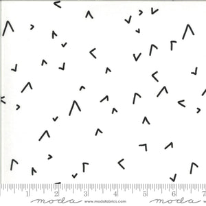 Black geometric pattern on white fabric with a ruler at the bottom