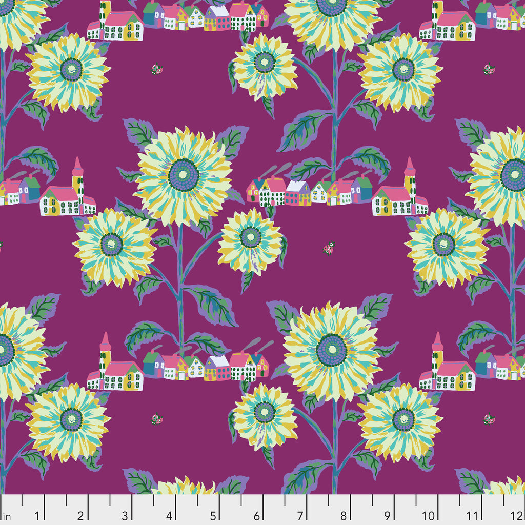 A piece of fabric with a floral pattern featuring sunflowers and a village design on a purple background.