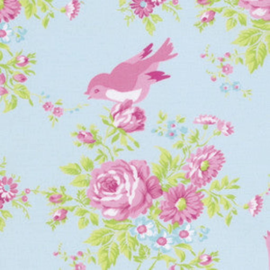 A piece of fabric featuring a floral and bird design with pink flowers and a pink bird on a blue background.