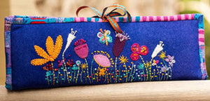 Embroidered fabric panel with colorful floral designs on a blue background