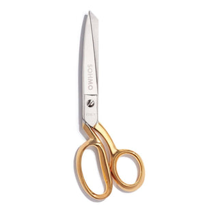 Scissors with gold handles on a white background