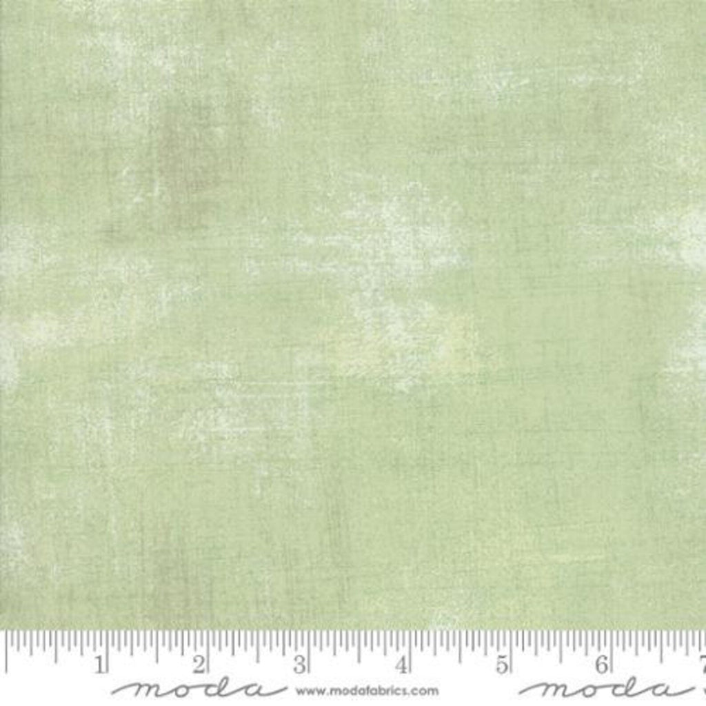Textured light green fabric with a ruler at the bottom for scale