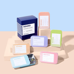 Collection of SOHMO branded products on a beige surface with a light blue background